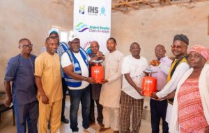 Dr Adam presenting cooking gas to some of the beneficiaries