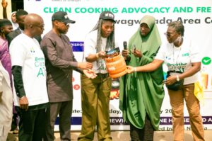 Dr Fasawe presenting the gas cylinders to one of the beneficiaries