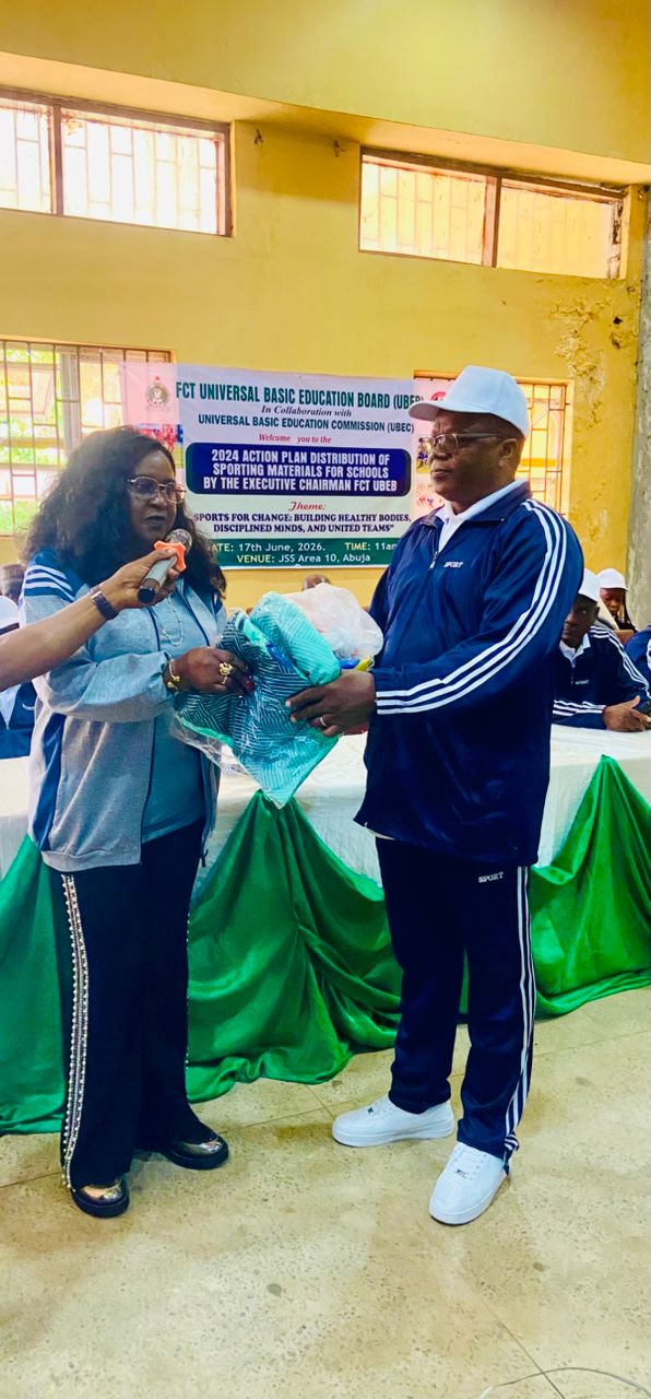 Wenegieme doing a symbolic presentation of nthe sporting equipment